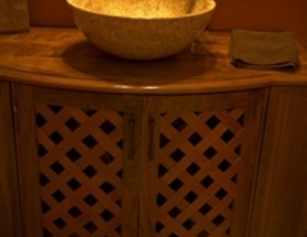 Guest Bath vanity cabinet with woven wood doors and stone vessel sink.